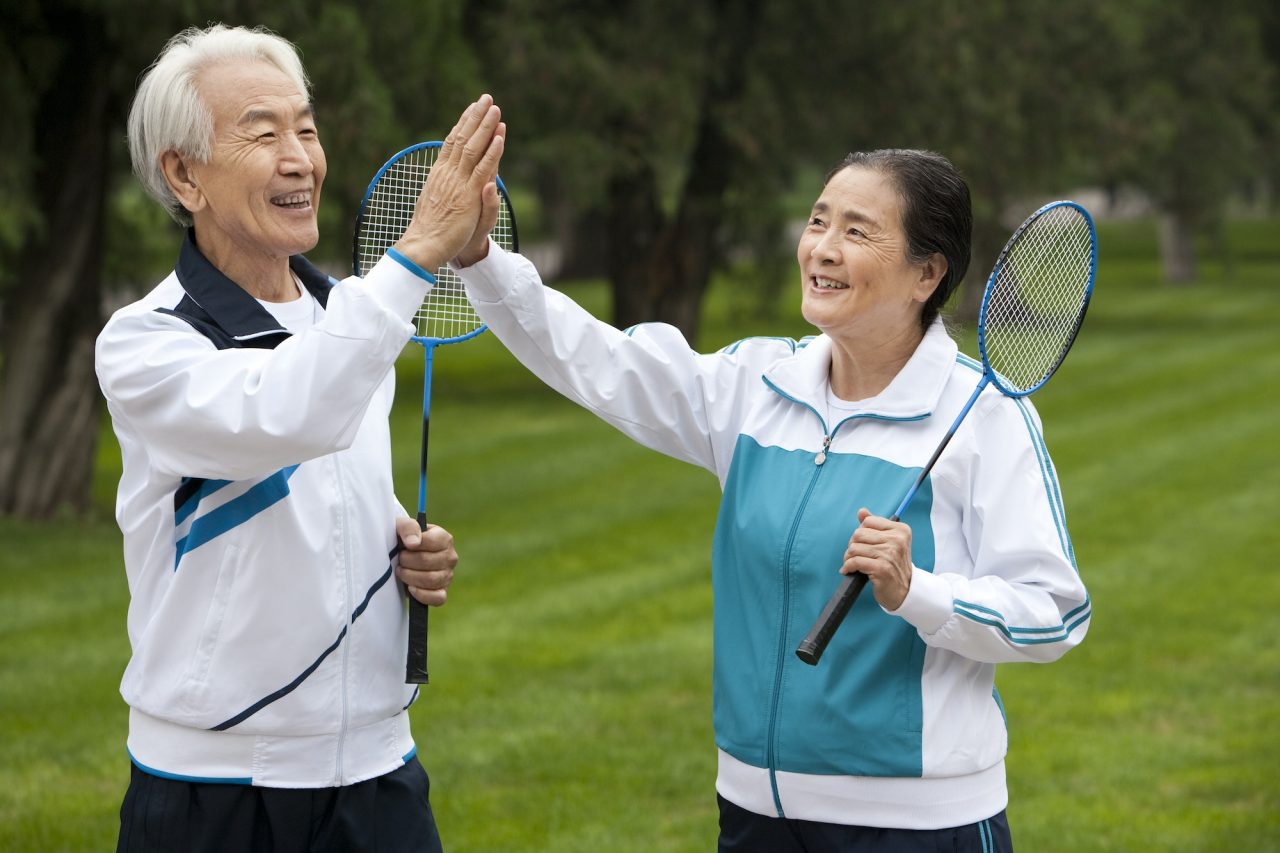 Senior Couple Holding Badminton Rackets in a Park